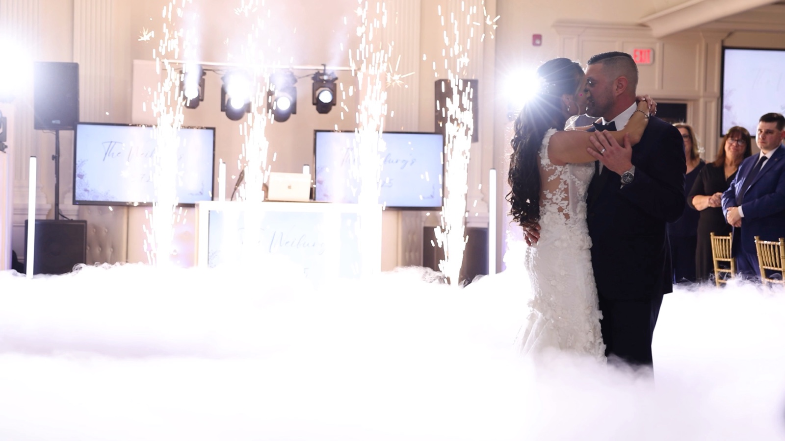 Cold spark fountains and a low cloud on the dance floor at Nanina's in the Park as the couple share their first dance, with the Disaronno Events booth, LED screens and moving-head lighting behind them