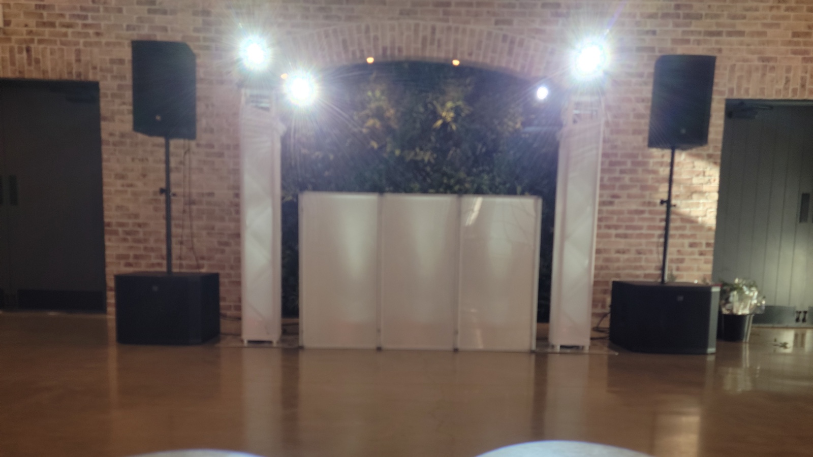 The Disaronno Events DJ setup at Perona Farms in Andover NJ — booth, speaker stacks and uplighting against the exposed brick and timber of the barn room